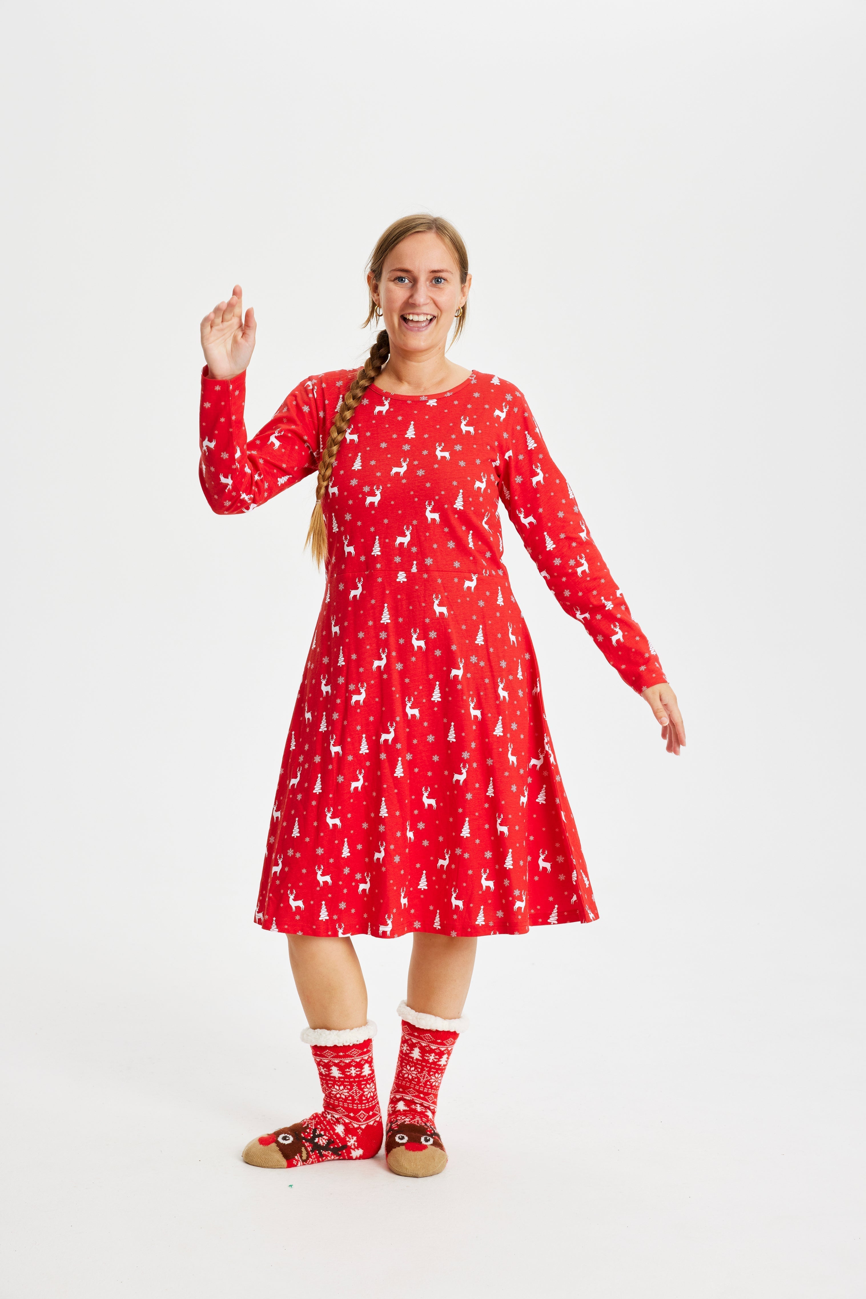 Een poserende vrouw in een rode kerstjurk.